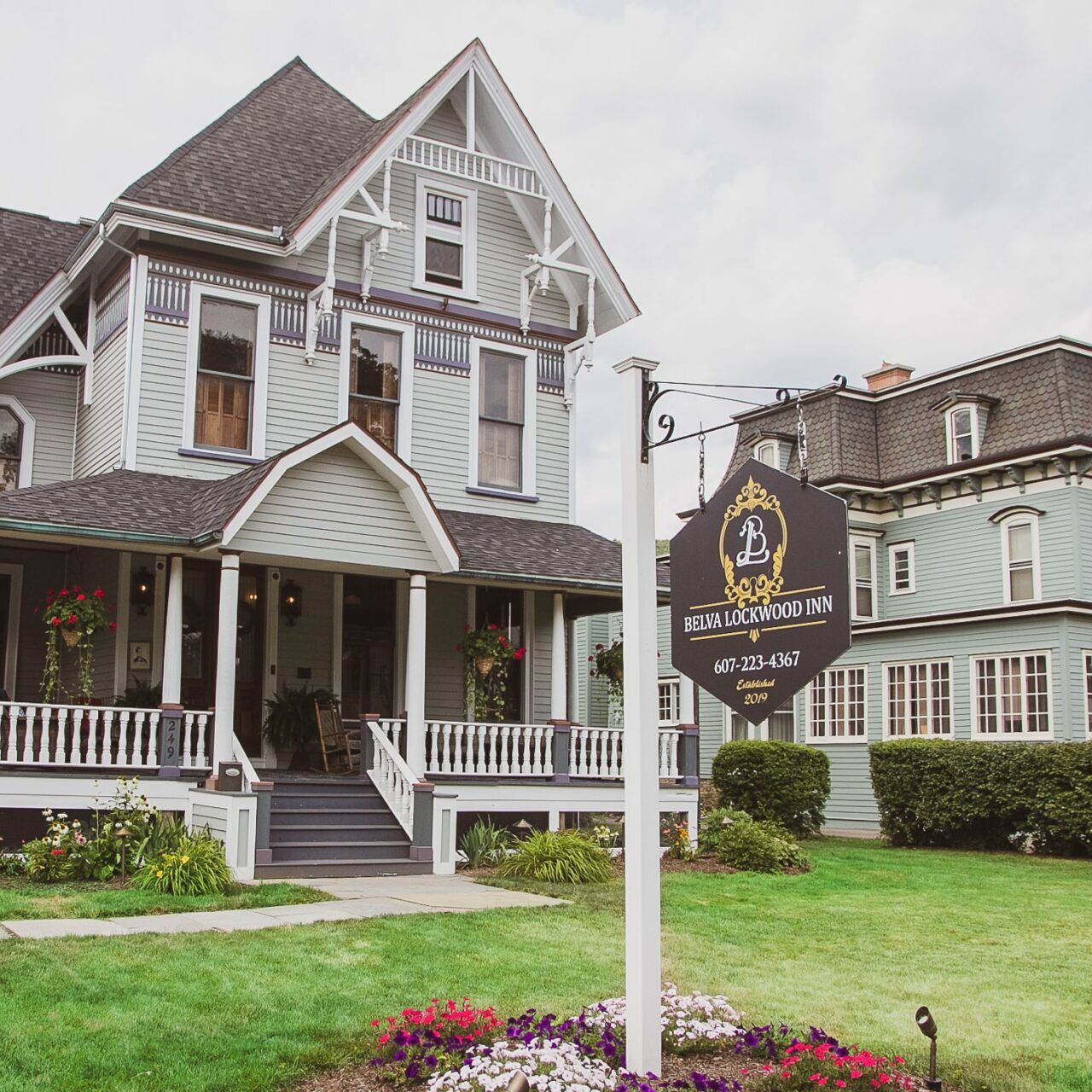 Victorian-style house lined with colorful flowers and "Belva Lockwood Inn" signage